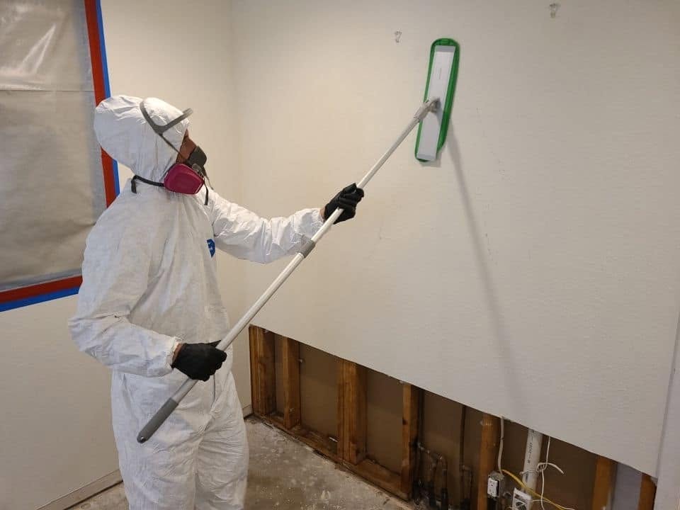 Industrial dehumidifiers and air movers drying water-damaged kitchen