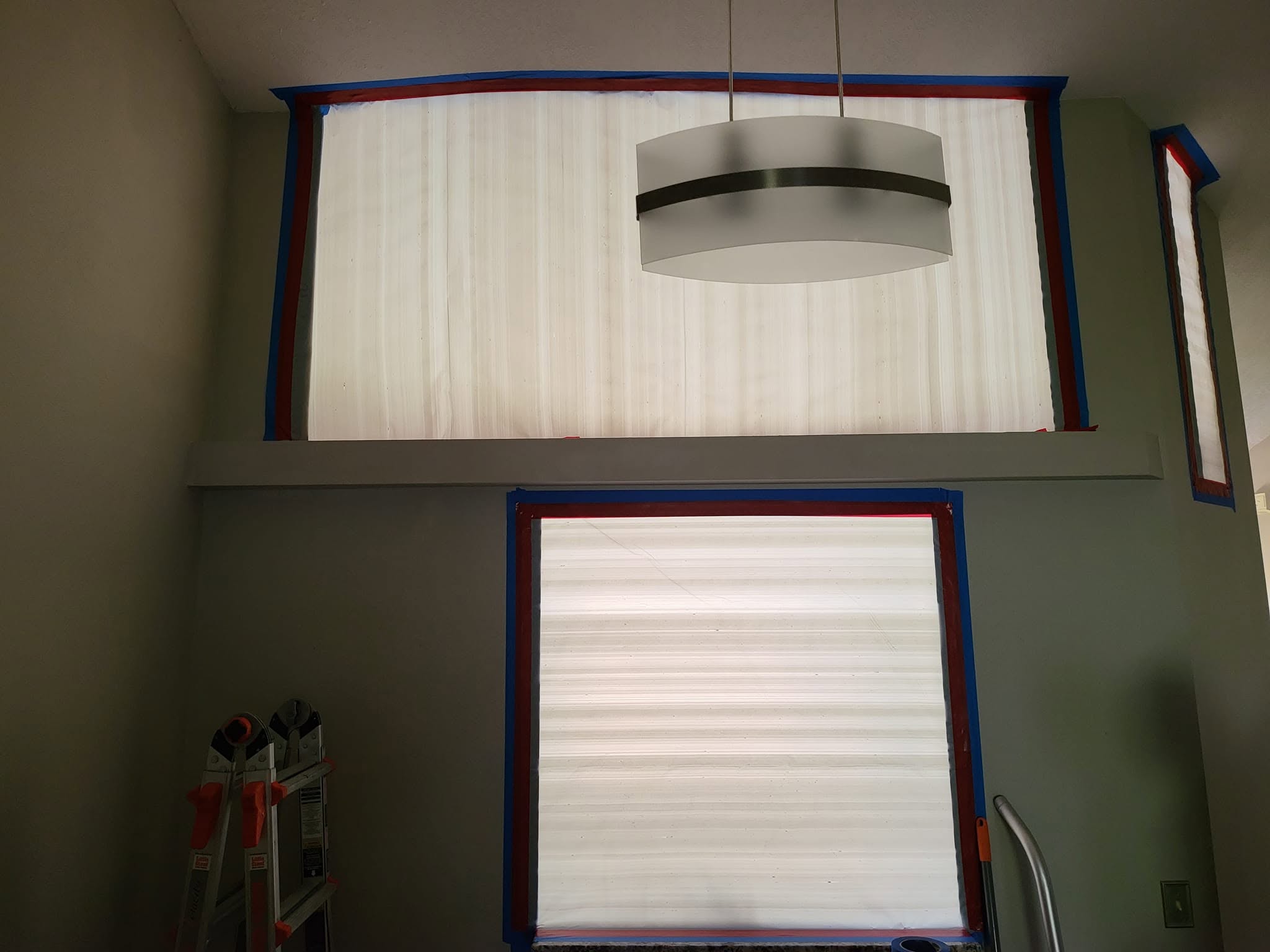 Mold remediation technician in PPE spraying treatment on wall with dehumidifier and air scrubber running in condo