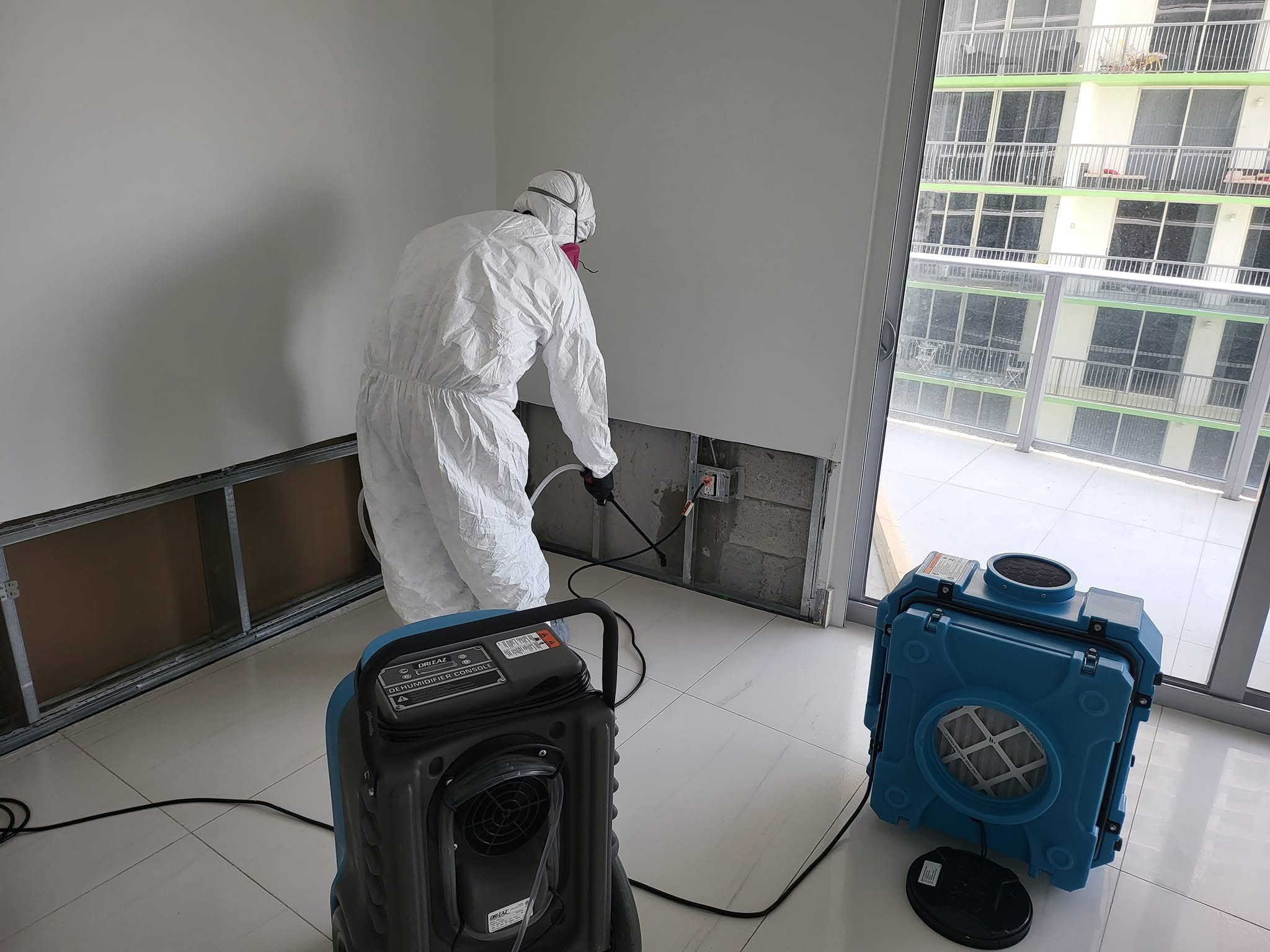 Multiple windows sealed with blue and red tape containment barriers throughout home during mold remediation