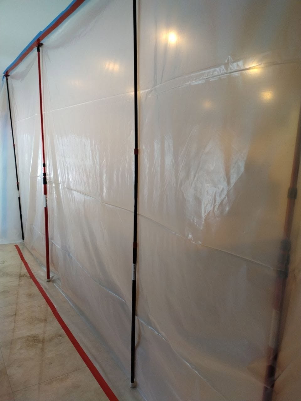 Under-sink water damage with black mold staining on subfloor and removed floor tiles
