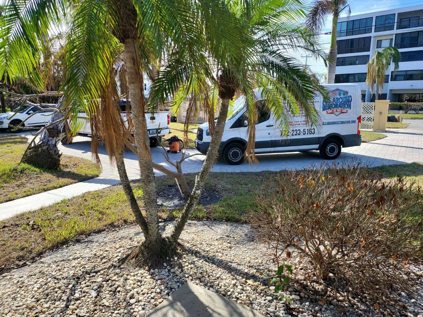 All Around Restoration technician loading stacked blue dehumidifiers and air movers into work van for water damage job